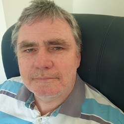 A head shot photo of David looking strait at the camera