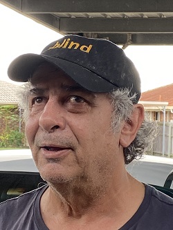 A photo of George from shoulders up smiling at the camera